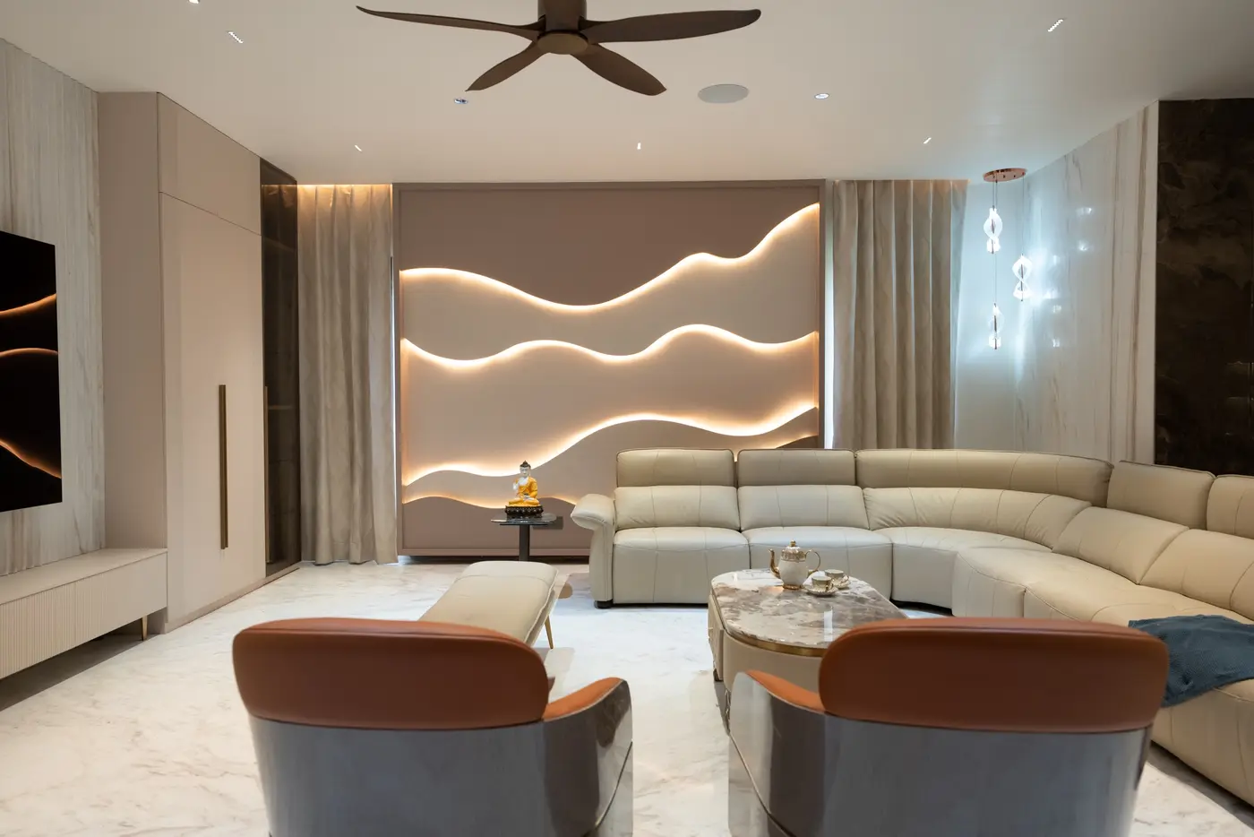 Living room with a backlit wave feature wall, cove lighting and pendant lights