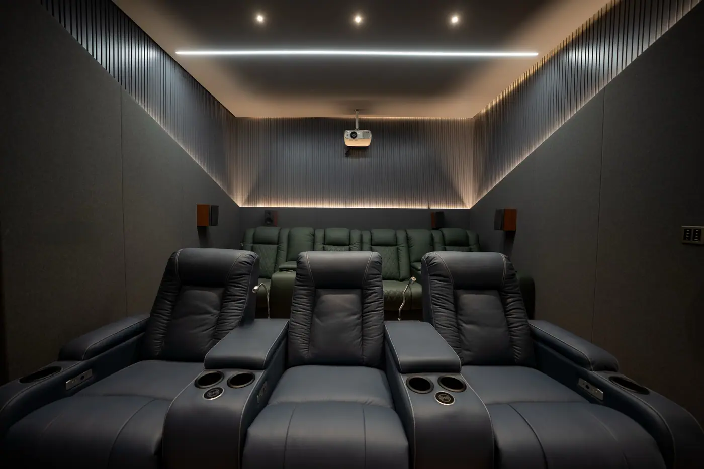 Home theatre with recliner seating, acoustic wall panels and a false ceiling with cove lighting