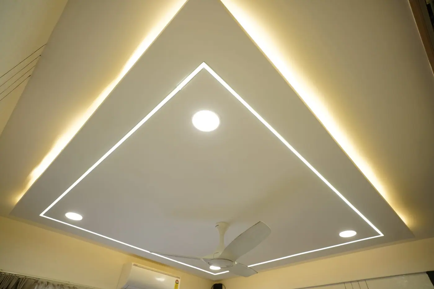 Bedroom false ceiling with a geometric cove light pattern and recessed spotlights