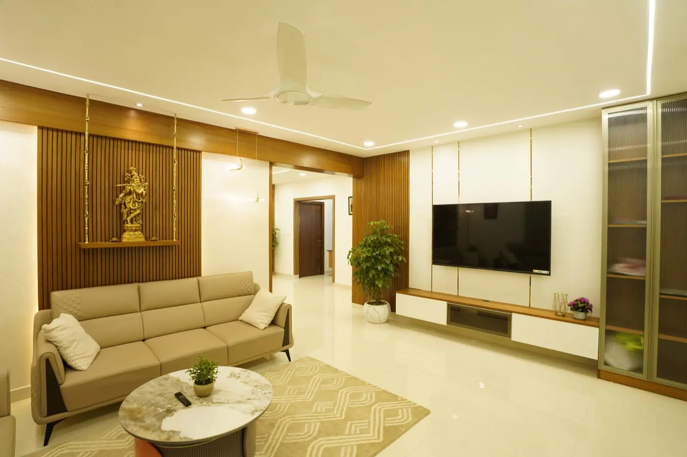Living room in warm beige with a light sofa, wood-finish TV wall and soft lighting